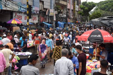 İnsanlar, 5 Temmuz 2020 'de Bangladeş' in Dhaka kentindeki Coronavirus salgını sırasında ihtiyaçlarını satın almak için bir sokak pazarında toplandılar.