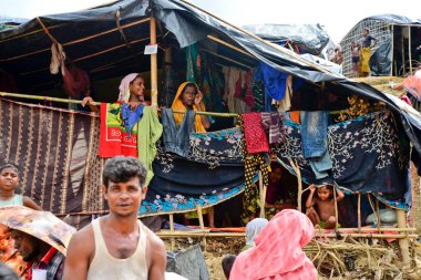 2006 Eylül 'ünde Bangladeş, Cox' s Bazar 'daki Palongkhali derme çatma kampında bir Rohingya mülteci aile üyesi oturuyor.