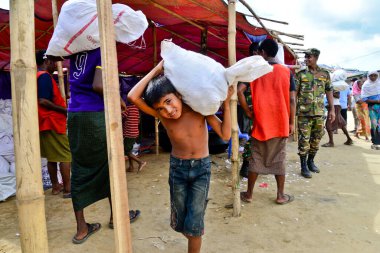 Rohingya mülteci çocuğu, 06 Eylül 2017 'de Bangladeş, Cox' s Bazar 'daki palongkhali derme çatma kampında lehimine yardım taşıyor.