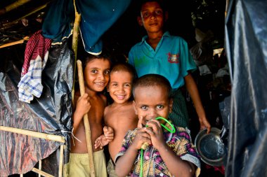 2006 Eylül 'ünde Bangladeş, Cox' s Bazar 'daki Palongkhali derme çatma kampında bir Rohingya mülteci aile üyesi oturuyor.