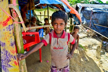 2006 Eylül 'ünde Bangladeş, Cox' s Bazar 'daki Palongkhali derme çatma kampında bir Rohingya mülteci aile üyesi oturuyor.