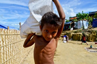 Rohingya mülteci çocuğu, 06 Eylül 2017 'de Bangladeş, Cox' s Bazar 'daki palongkhali derme çatma kampında lehimine yardım taşıyor.