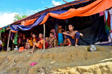 2006 Eylül 'ünde Bangladeş, Cox' s Bazar 'daki Palongkhali derme çatma kampında bir Rohingya mülteci aile üyesi oturuyor.