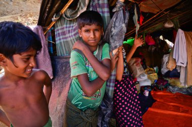 2006 Eylül 'ünde Bangladeş, Cox' s Bazar 'daki Palongkhali derme çatma kampında bir Rohingya mülteci aile üyesi oturuyor.