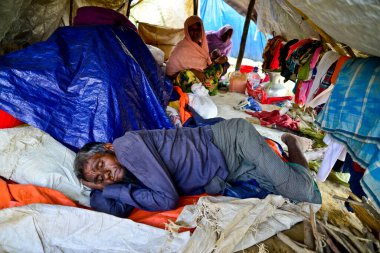 2006 Eylül 'ünde Bangladeş, Cox' s Bazar 'daki Palongkhali derme çatma kampında bir Rohingya mülteci aile üyesi oturuyor.
