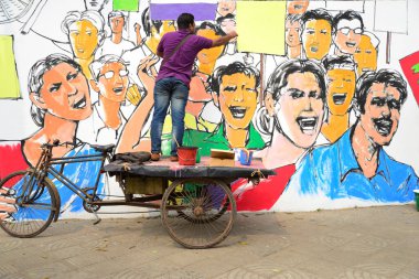Bangladeşli güzel sanatlar öğrencileri ve öğretmenleri 19 Şubat 2017 'de Dhaka' da Merkez Şehid Minar 'ın (dil hareketi anıtı) önünde bir duvara resim çizerler..