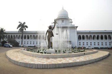 28 Ocak 2017 'de Bangladeş' in Dhaka kentindeki Anayasa Mahkemesi kompleksinin önünde duran bir Adalet Heykeli. Elinde terazi ve kılıç tutan bir kadın heykeli Aralık ayında mahkeme binasının dışına dikildi. Heykel sarıldı. 