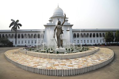 28 Ocak 2017 'de Bangladeş' in Dhaka kentindeki Anayasa Mahkemesi kompleksinin önünde duran bir Adalet Heykeli. Elinde terazi ve kılıç tutan bir kadın heykeli Aralık ayında mahkeme binasının dışına dikildi. Heykel sarıldı. 