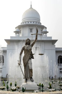 28 Ocak 2017 'de Bangladeş' in Dhaka kentindeki Anayasa Mahkemesi kompleksinin önünde duran bir Adalet Heykeli. Elinde terazi ve kılıç tutan bir kadın heykeli Aralık ayında mahkeme binasının dışına dikildi. Heykel sarıldı. 