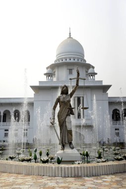 28 Ocak 2017 'de Bangladeş' in Dhaka kentindeki Anayasa Mahkemesi kompleksinin önünde duran bir Adalet Heykeli. Elinde terazi ve kılıç tutan bir kadın heykeli Aralık ayında mahkeme binasının dışına dikildi. Heykel sarıldı. 