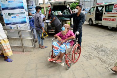 Bir Covid-19 hastası, 15 Temmuz 2020 'de Bangladeş, Dhaka' daki koronavirüs salgını sırasında tedavi görmek için Dhaka Tıp Fakültesi Hastanesi 'nin önünde akrabalarıyla birlikte bekliyor.