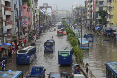Araçlar sürmeye çalışıyor ve vatandaşlar 22 Temmuz 2020 'de Bangladeş' teki Dhaka caddelerinde yürüyorlar. Şiddetli muson yağmurları Bangladeş 'in Dhaka şehrinin birçok bölgesinde aşırı su tomrukçuluğuna yol açtı..