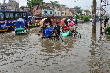 Araçlar sürmeye çalışıyor ve vatandaşlar 22 Temmuz 2020 'de Bangladeş' teki Dhaka caddelerinde yürüyorlar. Şiddetli muson yağmurları Bangladeş 'in Dhaka şehrinin birçok bölgesinde aşırı su tomrukçuluğuna yol açtı..