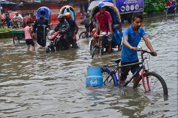 Vehicles try driving and citizens are walking through the water logging Dhaka streets in Bangladesh, on July 22, 2020. Heavy monsoon downpour caused extreme water logging in most areas of Dhaka city, Bangladesh.