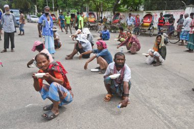 25 Temmuz 2020 'de Bangladeş' in Dhaka kentindeki COVID-19 Coronavirüs salgını sırasında insanlar yiyecek yardımı almak için kuyrukta bekliyorlar.