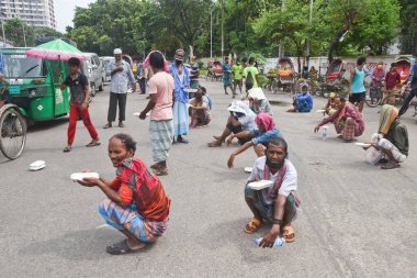 25 Temmuz 2020 'de Bangladeş' in Dhaka kentindeki COVID-19 Coronavirüs salgını sırasında insanlar yiyecek yardımı almak için kuyrukta bekliyorlar.