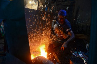  Demirci, Bangladeş, Dhaka 'da 28 Temmuz 2020' de bıçak üretiyor. Kurban edilecek sığırların kurban edilmesinde kullanılacak..  