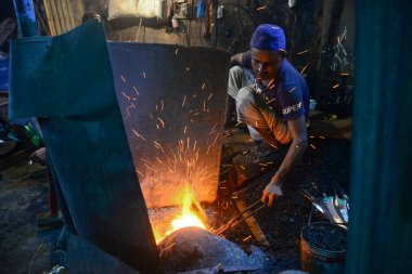  Demirci, Bangladeş, Dhaka 'da 28 Temmuz 2020' de bıçak üretiyor. Kurban edilecek sığırların kurban edilmesinde kullanılacak..  