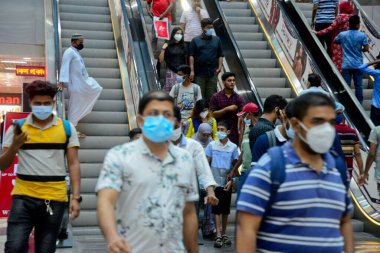 Bangladeşli müşteriler, 29 Temmuz 2020 'de Bangladeş' in Dhaka kentindeki COVID-19 Coronavirus salgını sırasında Kurban 'ın önündeki bir alışveriş merkezinden kıyafet almak için yüz maskesi takıyorlar.