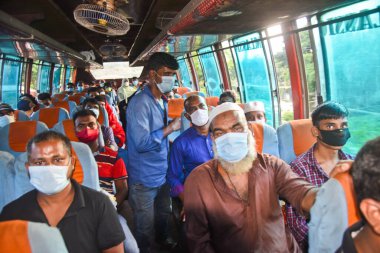 Maske takan insanlar, 5 Ağustos 202 'de Bangladeş, Dhaka' daki Kurban Bayramı 'nın bitiminden sonra başkente dönerken otobüsle seyahat ediyorlar.