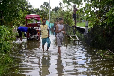 Vatandaşlar 6 Ağustos 202 'de Bangladeş' in Dhaka şehrinin ovalardaki bir su birikintisinde yürürler.