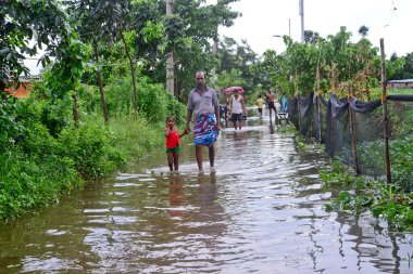 Vatandaşlar 6 Ağustos 202 'de Bangladeş' in Dhaka şehrinin ovalardaki bir su birikintisinde yürürler.