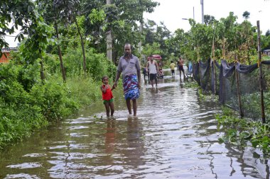 Vatandaşlar 6 Ağustos 202 'de Bangladeş' in Dhaka şehrinin ovalardaki bir su birikintisinde yürürler.