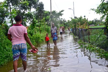 Vatandaşlar 6 Ağustos 202 'de Bangladeş' in Dhaka şehrinin ovalardaki bir su birikintisinde yürürler.