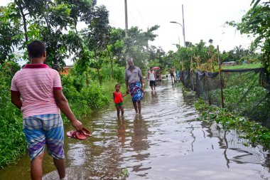Vatandaşlar 6 Ağustos 202 'de Bangladeş' in Dhaka şehrinin ovalardaki bir su birikintisinde yürürler.