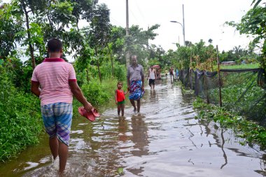 Vatandaşlar 6 Ağustos 202 'de Bangladeş' in Dhaka şehrinin ovalardaki bir su birikintisinde yürürler.