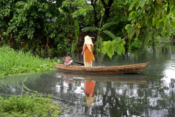 Vatandaşlar 6 Ağustos 2020 'de Bangladeş' in Dhaka şehrinin ovalarında sel sularından geçen bir tekneye biniyorlar.