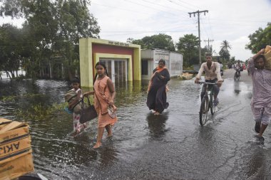 7 Ağustos 202 'de Dhaka, Bangladeş yakınlarındaki sel basmış caddede köylüler yürüyor.