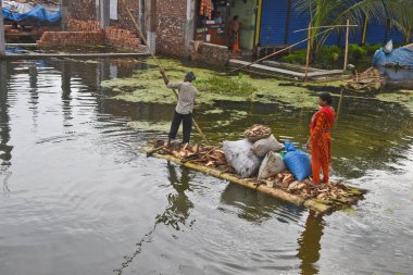 Village man ride on makeshift raft made of banana trees in the flood water in Savar near Dhaka, Bangladesh, on August 7, 2020 clipart