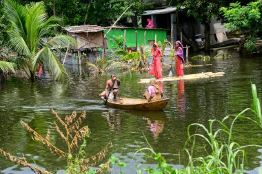 10 Ağustos 2020 'de, Dhaka, Bangladeş yakınlarındaki Savar' da, sel sularından geçen bir tekneye binen köylüler.