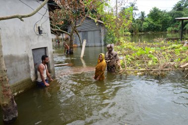 10 Ağustos 2020 'de Dhaka, Bangladeş yakınlarındaki sel basmış caddede köylüler yürüyor.