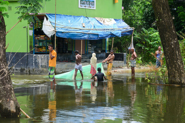 Villagers walk through in the flooded street in Savar near Dhaka, Bangladesh, on August 10, 2020