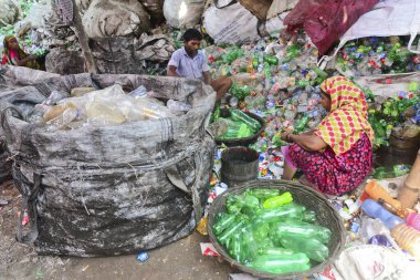 Kadın işçiler, 12 Ağustos 2020 'de Dhaka, Bangladeş' teki bir geri dönüşüm fabrikasında polietilen tereftalat (PET) şişelerini sınıflandırıyorlar. Plastik şişelerin geri dönüşümü son birkaç yılda büyüyen bir iş haline geldi. 