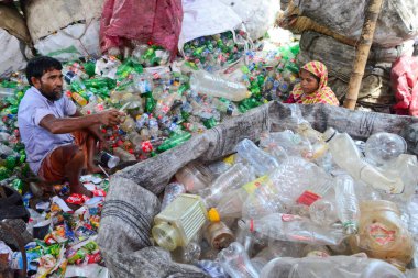 Kadın işçiler, 12 Ağustos 2020 'de Dhaka, Bangladeş' teki bir geri dönüşüm fabrikasında polietilen tereftalat (PET) şişelerini sınıflandırıyorlar. Plastik şişelerin geri dönüşümü son birkaç yılda büyüyen bir iş haline geldi. 