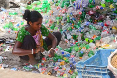 Kadın işçiler, 12 Ağustos 2020 'de Dhaka, Bangladeş' teki bir geri dönüşüm fabrikasında polietilen tereftalat (PET) şişelerini sınıflandırıyorlar. Plastik şişelerin geri dönüşümü son birkaç yılda büyüyen bir iş haline geldi. 
