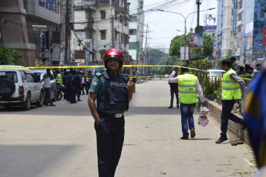 Bangladeş polis memurları, 15 Ağustos 2017 'de Dhaka' da sözde bir militan sığınağını basmak için düzenlenen operasyonun olay yerinde nöbet tutuyorlar. Dhakas Panthapath 'taki bir otelde düzenlenen operasyonda şüpheli bir militan öldürüldü..