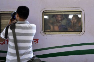 Bangladeşli yolcular, 23 Haziran 2017 'de Bangladeş' in Dhaka kentindeki bir tren istasyonunda bayram öncesi kutlama yapmak üzere aşırı kalabalık bir trenle evlerine dönüyorlar. Dhaka 'da çalışan yüz binlerce insan memleketlerine gidiyor.