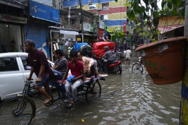19 Haziran 2015 'te sağanak yağış neredeyse durgunluğa yol açtıktan sonra vatandaşlar, araçlar ve Rickshaw' lar Dhaka 'nın sel basmış sokaklarında yolcularla birlikte araba sürmeye çalıştı. Şiddetli muson yağmurlarının ardından Dhaka 'nın başkentinde bölgenin çoğu sular altında kaldı..