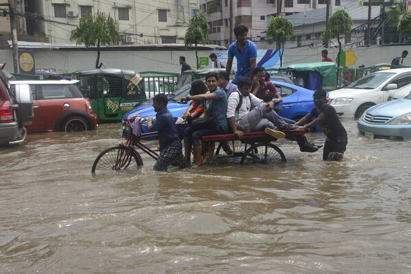 Citizens are walking through the flooded streets of Dhaka after heavy rainfalls caused almost-standstill, on July 26, 2017. After heavy monsoon rains caused flooded most of area in the capital of Dhaka in Bangladesh. 