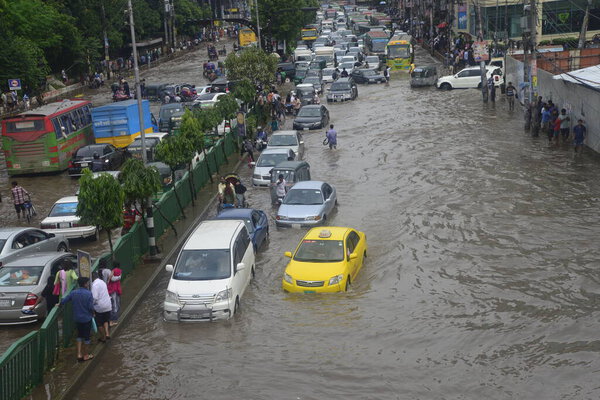 Citizens are walking through the flooded streets of Dhaka after heavy rainfalls caused almost-standstill, on July 26, 2017. After heavy monsoon rains caused flooded most of area in the capital of Dhaka in Bangladesh. 