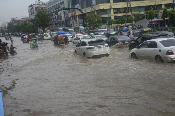 26 Temmuz 2017 'de sağanak yağış neredeyse durgunluğa yol açtıktan sonra, vatandaşlar Dhaka' nın sel basmış sokaklarında yürüyor. Şiddetli muson yağmurlarının ardından Bangladeş 'in başkenti Dhaka' nın büyük bölümü sular altında kaldı.. 