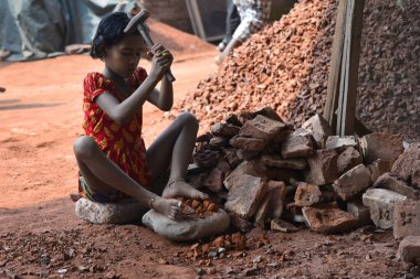 A Bangladeshi Child break bricks at Demra brick breaking yard in Dhaka, Bangladesh, On May 13, 2017. With over half of the population living below the poverty line, women and children are often forced into hard manual labour such as brick breaking. W clipart