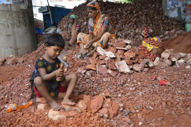 Bangladeşli kadınlar ve çocuklar 13 Mayıs 2017 'de Dhaka, Bangladeş' teki Demra tuğla kırma sahasında tuğla kırarlar. Nüfusun yarısından fazlası yoksulluk sınırının altında yaşadığı için, kadınlar ve çocuklar çoğunlukla tuğla gibi ağır işçiliğe zorlanıyorlar.