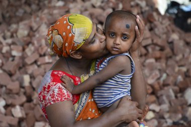 Çalışan bir anne çocuğunu Bangladeş, Dhaka 'daki iş yerinde öper. 13 Mayıs 201