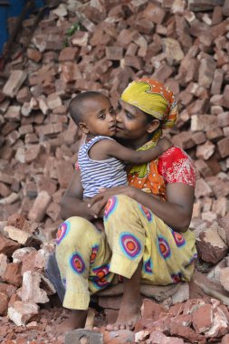 Çalışan bir anne çocuğunu Bangladeş, Dhaka 'daki iş yerinde öper. 13 Mayıs 201