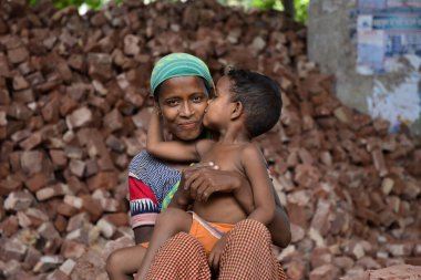İşçi bir anne, Bangladeş 'te, Dhaka' da çocuklarının iş yerinde öpüşürken eğleniyor. 13 Mayıs 2017